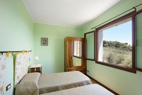 um quarto com 2 camas e uma janela em Casale Filiberto Terrazza em Diano San Pietro