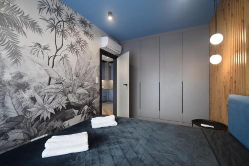 um quarto com uma cama com um mural tropical na parede em Apartamenty LookAp Ustronie Morskie I przy plaży em Ustronie Morskie