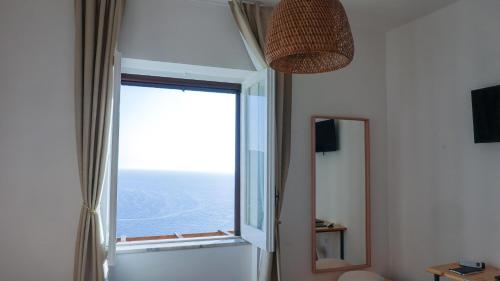 a bathroom with a large window and a mirror at Castellabate Apartments Camere in Castellabate