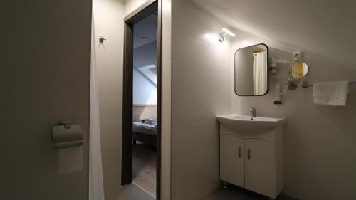 a bathroom with a sink and a mirror at Jam Panzió in Kapuvár