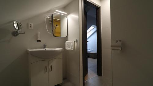 a bathroom with a sink and a mirror at Jam Panzió in Kapuvár