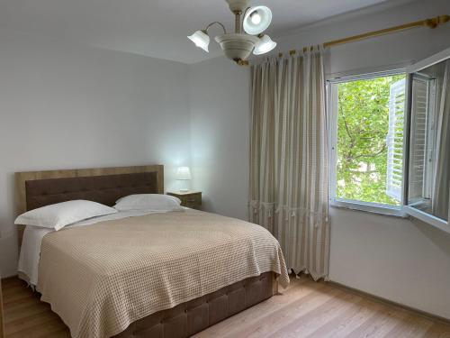a bedroom with a bed and a large window at Lovely one-bedroom apartment with private entrance in Tirana
