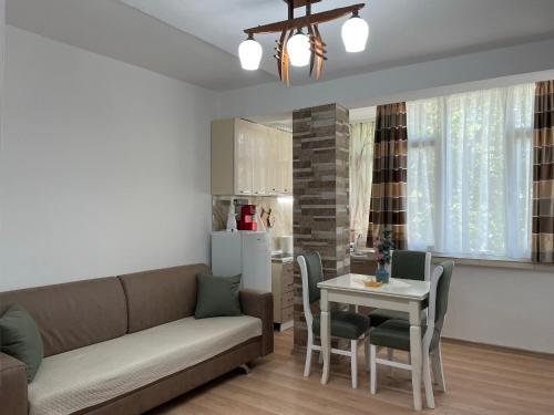 a living room with a couch and a table at Lovely one-bedroom apartment with private entrance in Tirana