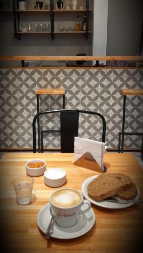een tafel met een kop koffie en een sandwich bij Casa Be Suites in Rosario