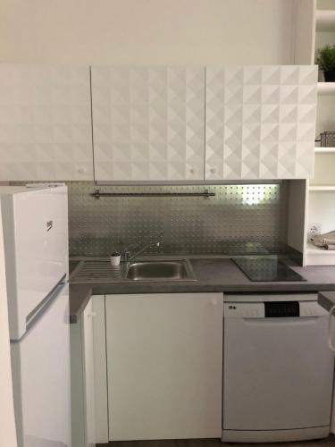 eine Küche mit weißen Schränken und einem Waschbecken in der Unterkunft appartmentslapiazzetta - n.4 in Sesto Calende