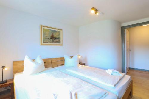 a bedroom with a large bed with white sheets and pillows at Apartments im Einhornhaus in Lübeck