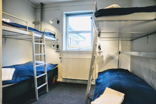 two bunk beds in a room with a window at Danhostel Svendborg in Svendborg