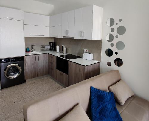 a living room with a couch and a kitchen at Lovely 1-bedroom unit @ fabulous location in Paphos City