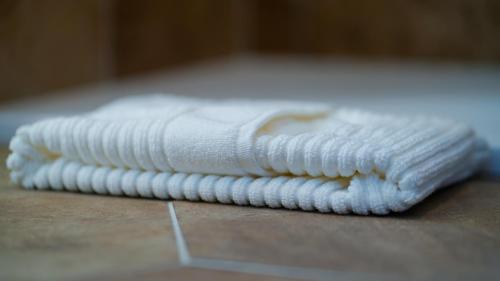 a stack of white towels sitting on a table at Castellabate Apartments Camere in Castellabate