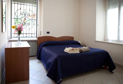 um quarto com uma cama e um vaso com toalhas em B&B Casa Liberty em Acqui Terme