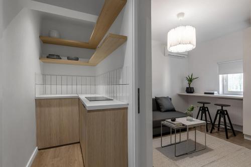 a kitchen and living room with a couch and a table at Little Attic by CityLife Suites in Bucharest