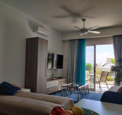 a living room with a couch and a television at Lovely 1-bedroom unit @ fabulous location in Paphos City