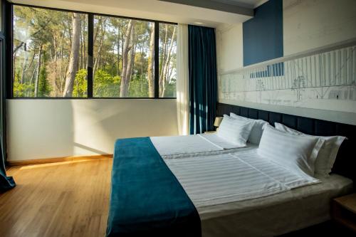 a bedroom with a large bed with a large window at Graphica Black Sea in Shekhvetili