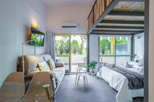 sala de estar con sofá y cama en OleHolidays 405 Loft Romana Playa junto al mar, en Marbella