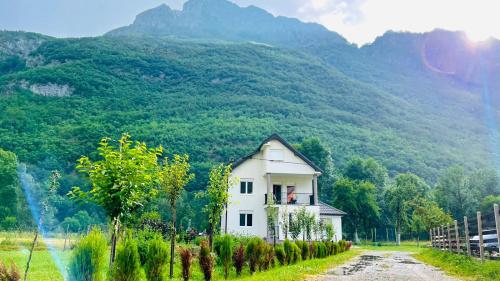 a small white house in front of a mountain at A Breath of Fresh Air in Gusinje