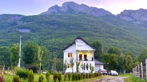 a small white house in front of a mountain at A Breath of Fresh Air in Gusinje