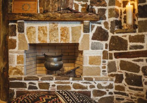 a stone fireplace with a vase on top of it at Traditional house Alexis Coco with pool and fire place in Tríkorfon