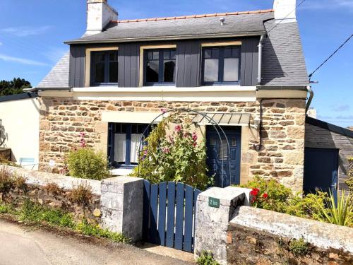 a house with a blue fence in front of it at La petite maison du coin de Loguivy de la Mer in Ploubazlanec