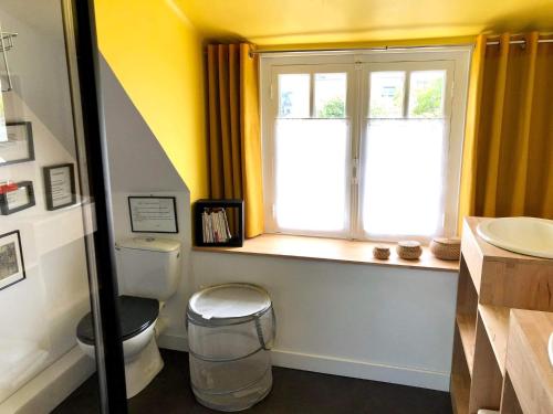 a bathroom with a toilet and a window at La petite maison du coin de Loguivy de la Mer in Ploubazlanec