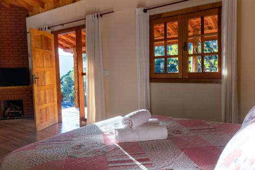 a bedroom with a bed with towels on it at Aconchegante chale com Wi Fi em Sapucai Mirim MG in Gonçalves
