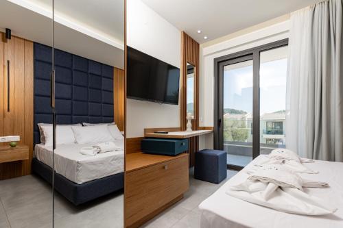 a bedroom with two beds and a flat screen tv at Daria Essence in Limenas