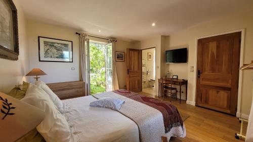 Dormitorio con cama, escritorio y TV en Aux Rives de Honfleur, en Berville-sur-Mer