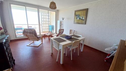 un salon avec une table et des chaises blanches dans l'établissement LES FLOTS BLEUS - Appartement 2 chambres vue mer, à Saint-Jean-de-Monts