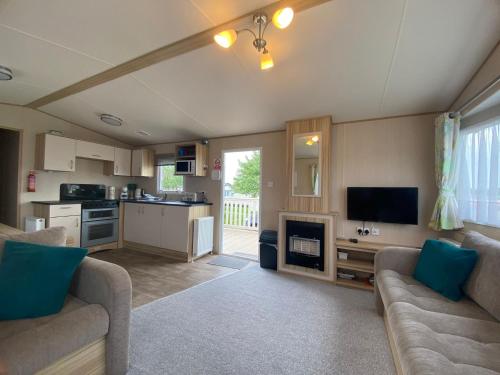 a living room with a couch and a tv and a kitchen at The Hideaway in Cayton