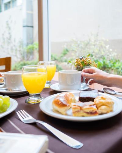een tafel met een bord ontbijtproducten en jus d'orange bij Lagos Andinos in Bariloche