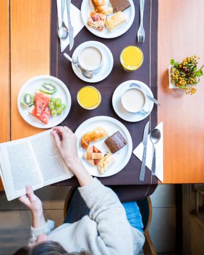 iemand die een boek leest aan een tafel met eten bij Lagos Andinos in Bariloche
