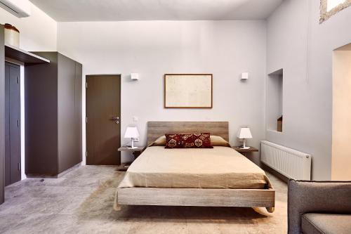 a bedroom with a bed and two tables with lamps at Nikolaou residence in Aegina Town