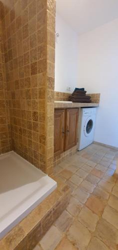 ein Badezimmer mit einer Waschmaschine und Fliesenboden in der Unterkunft Ma vie là in Patrimonio