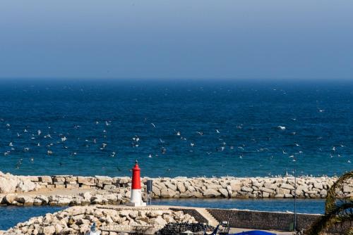 a red and white lighthouse next to the ocean at Estepona Marina with Sea Views, Pool and Parking in Estepona