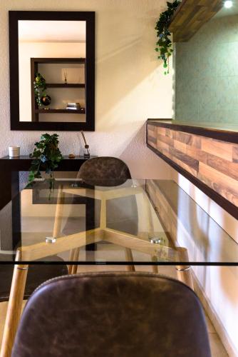 a glass table with two chairs and a mirror at Estepona Marina with Sea Views, Pool and Parking in Estepona