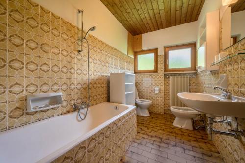 a bathroom with a tub and a sink and a toilet at Ciasa La Palsa App 4 in San Vigilio Di Marebbe
