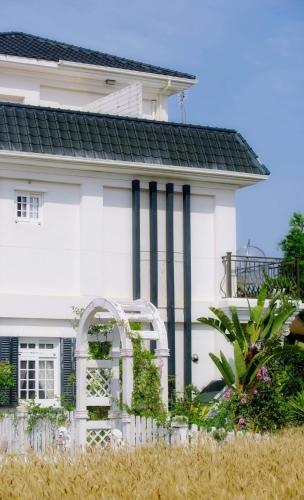 a white house with a white fence in front of it at 海之風 玫瑰莊園 Sea&Wind Rose Manor in Jinning