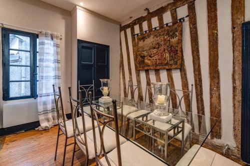 une salle à manger avec une table et des chaises en verre dans l'établissement La Maison Taillefer, à Lauzun