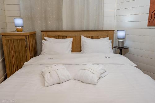 a large white bed with two towels on it at Nofesh Baharim in Ramot Naftali
