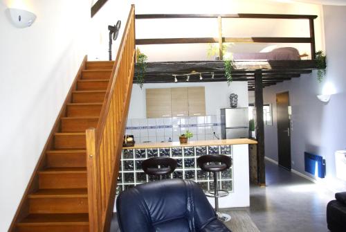 een kamer met een trap en een bar met krukken bij Mezzanine Pétillante in Châlons-en-Champagne