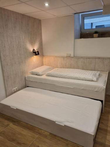 2 Betten in einem Zimmer mit Fenster in der Unterkunft Welcome Apartment Cölbe in Cölbe