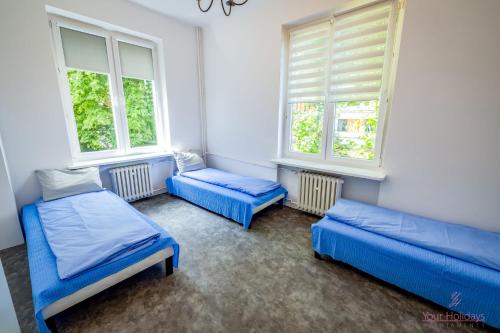 a room with two beds and two windows at Pokoje Fregata Świnoujście in Świnoujście