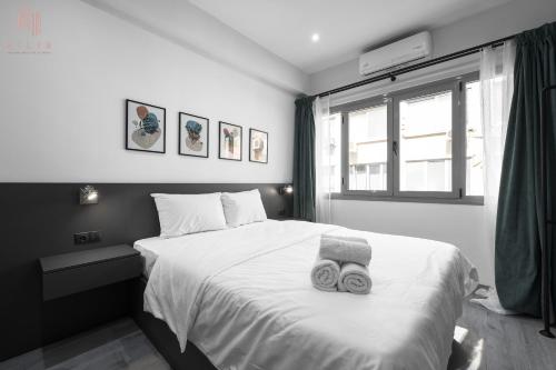 um quarto com uma cama com duas toalhas em New Era, Nilie Hospitality MGMT em Tessalônica