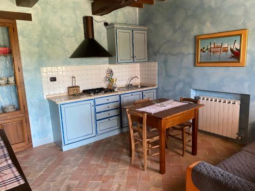 a kitchen with a table and a sink and a stove at Caiferri Agriturismo in Gubbio