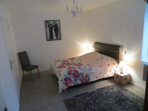 1 dormitorio con cama, lámpara y silla en Les Studios-Hôtel de Sommières en Sommières