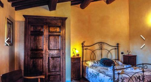 a bedroom with a bed and a wooden door at Caiferri Agriturismo in Gubbio