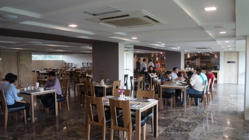 a group of people sitting at tables in a restaurant at Hotel Parami in Yangon