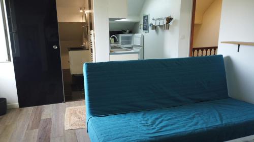 - un canapé bleu dans une chambre avec cuisine dans l'établissement Appartement cosy à quelques mètres de la plage, à Pornichet