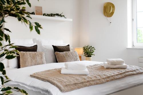 a white bedroom with a large white bed with two pillows on it at Beautiful Apartments With Parking In a Quiet Location in Ostrava