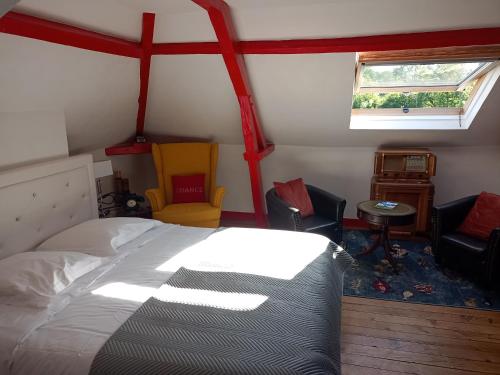 een slaapkamer met een bed en 2 stoelen en een raam bij La Cour Du Puits Chambre Victor in Cormeilles