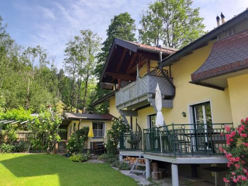 a yellow house with a balcony and a yard at Appartement Genigau in Wagrain